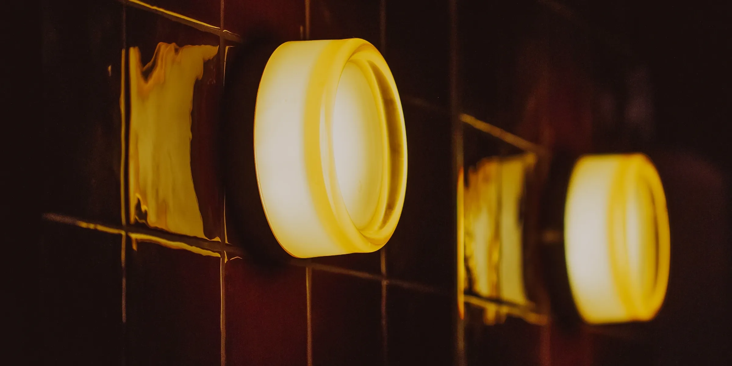 Appliques rondes diffusant une lumière chaude sur la faïence du studio