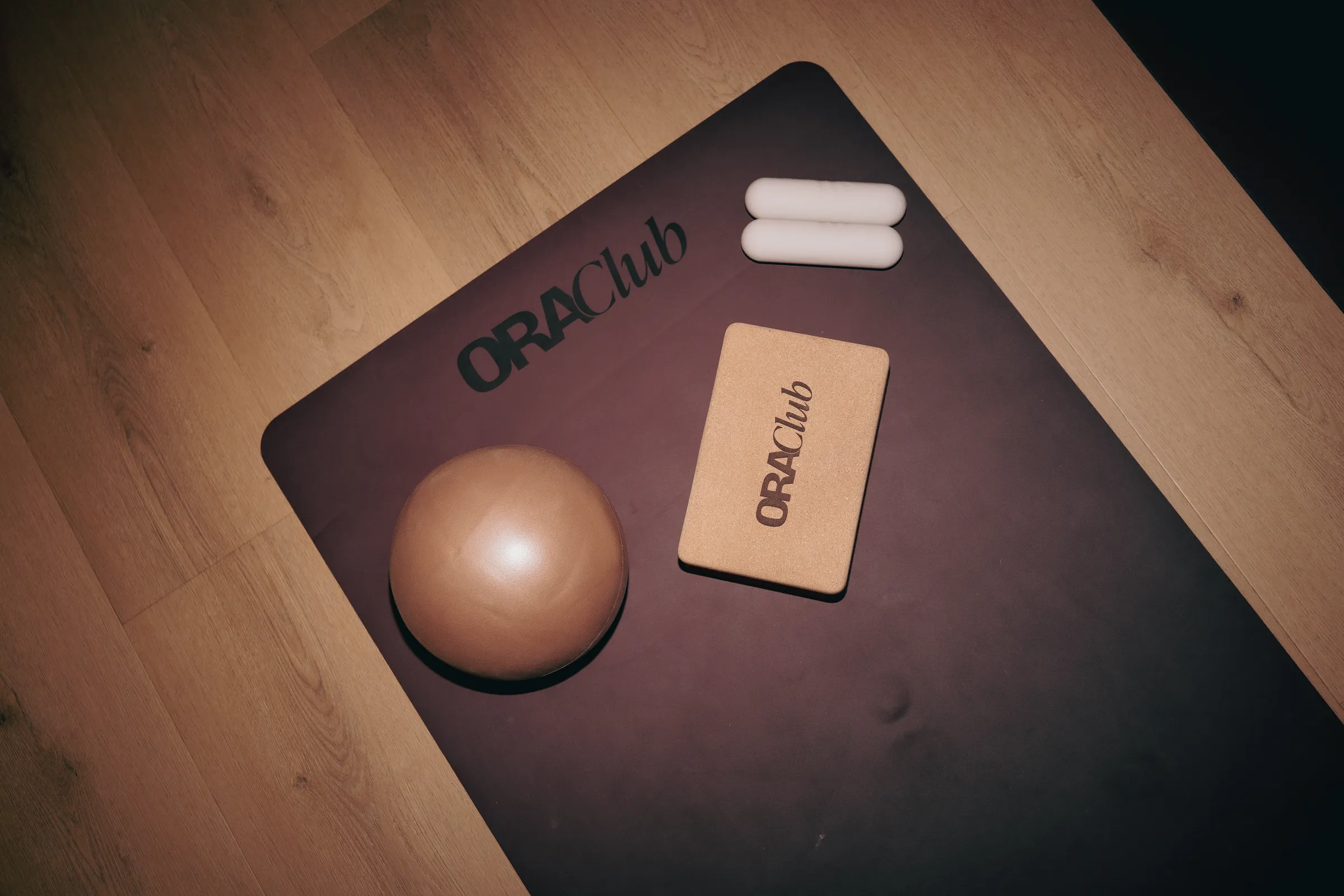 Tapis Ora Club vu de dessus avec un ballon, une brique en liège et deux haltères