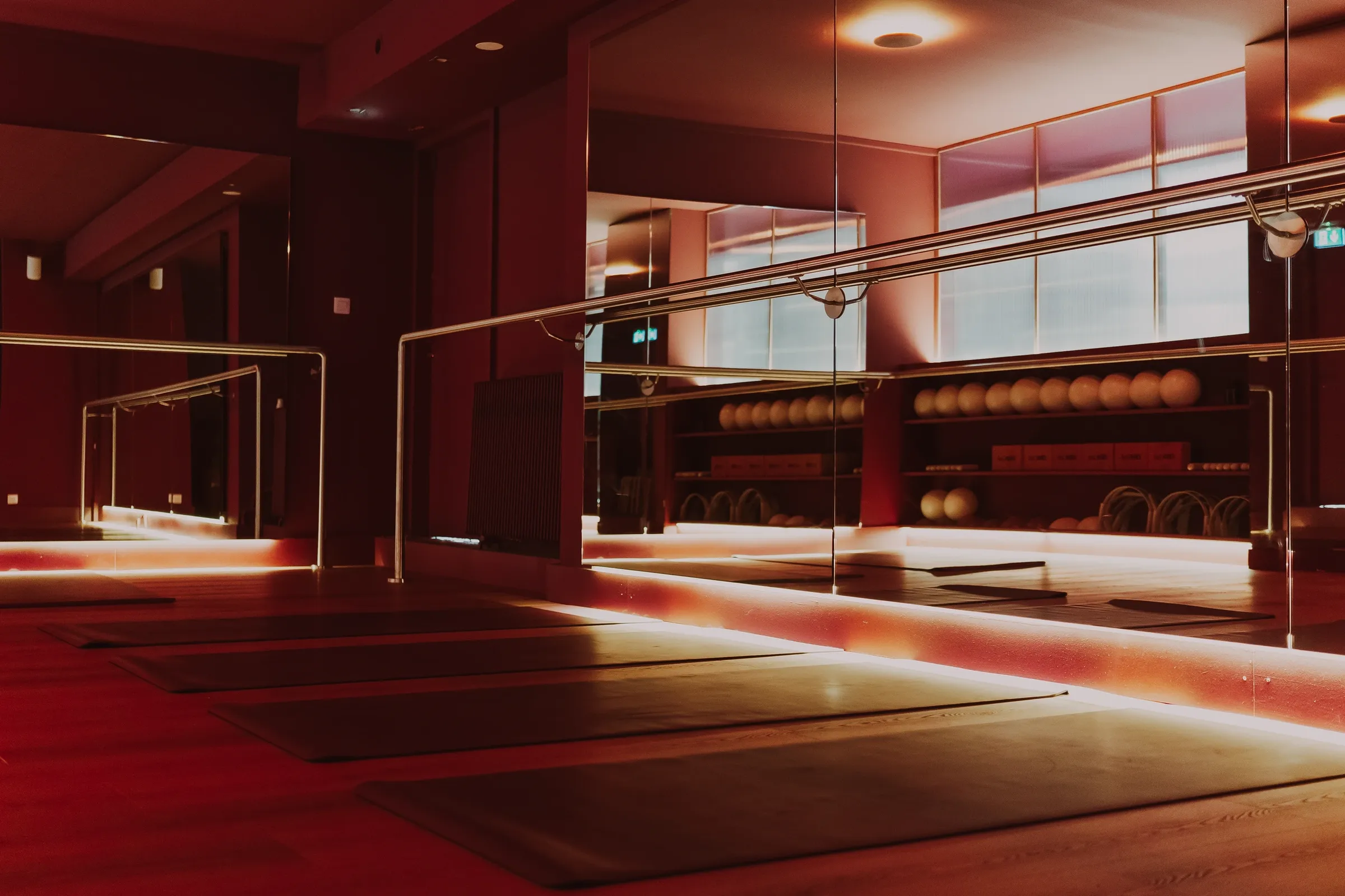 Salle de Barre du studio Ora Club aux Carmes à Toulouse : barres, miroirs et tapis dans une lumière chaude